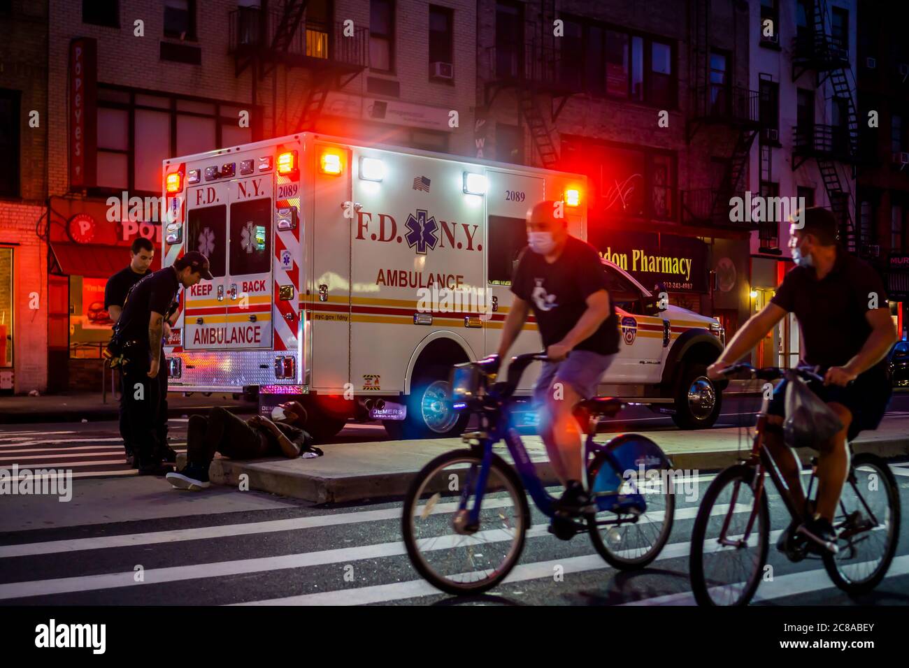 FDNY EMT workers respond to an individual sleeping in a traffic island in Chelsea in New York on Sunday, July 12, 2020. (© Richard B. Levine) Stock Photo