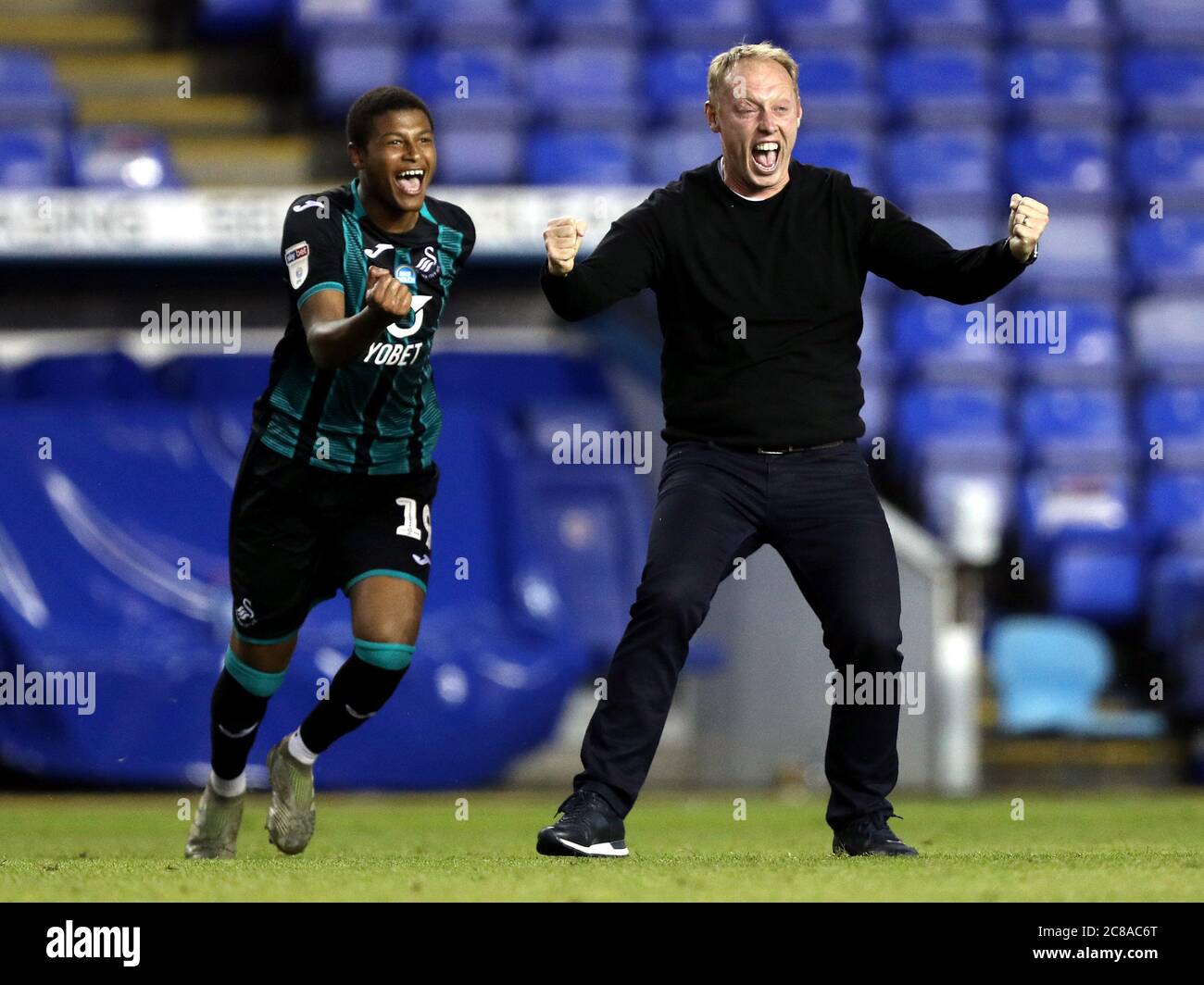 Swansea City manager Steve Cooper (right) and Rhian Brewster celebrate reaching the playoffs after the final whistle during the Sky Bet Championship match at the Madejski Stadium, Reading. Stock Photo