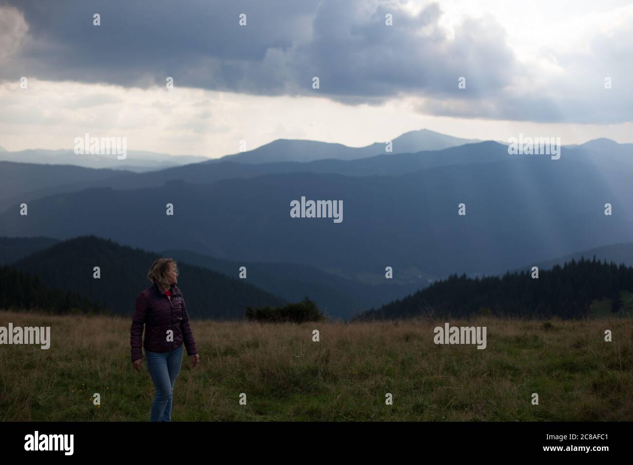 dramatic weather sun rays girl tourist climbed to the top in the carpathian mountains Stock Photo