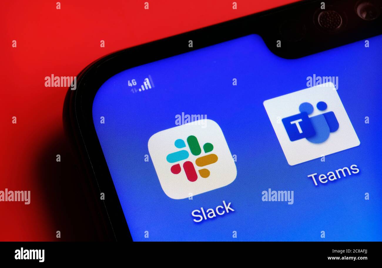 Stone / United Kingdom - July 22 2020: Slack and Teams apps on the corner smartphone screen placed on the red background. Concept for competition. Stock Photo