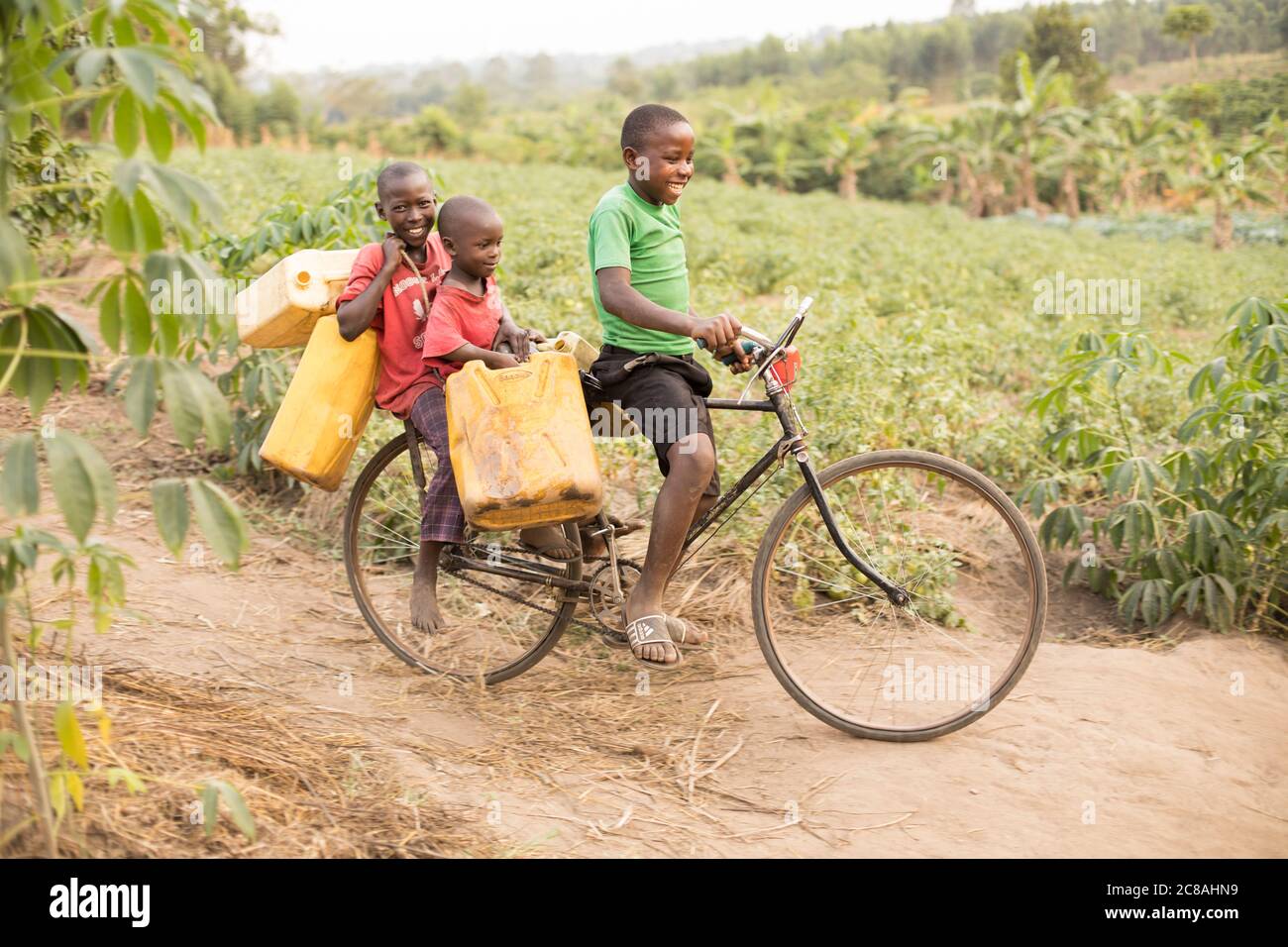 Children use a bicycle to fetch and carry water in a rural village in