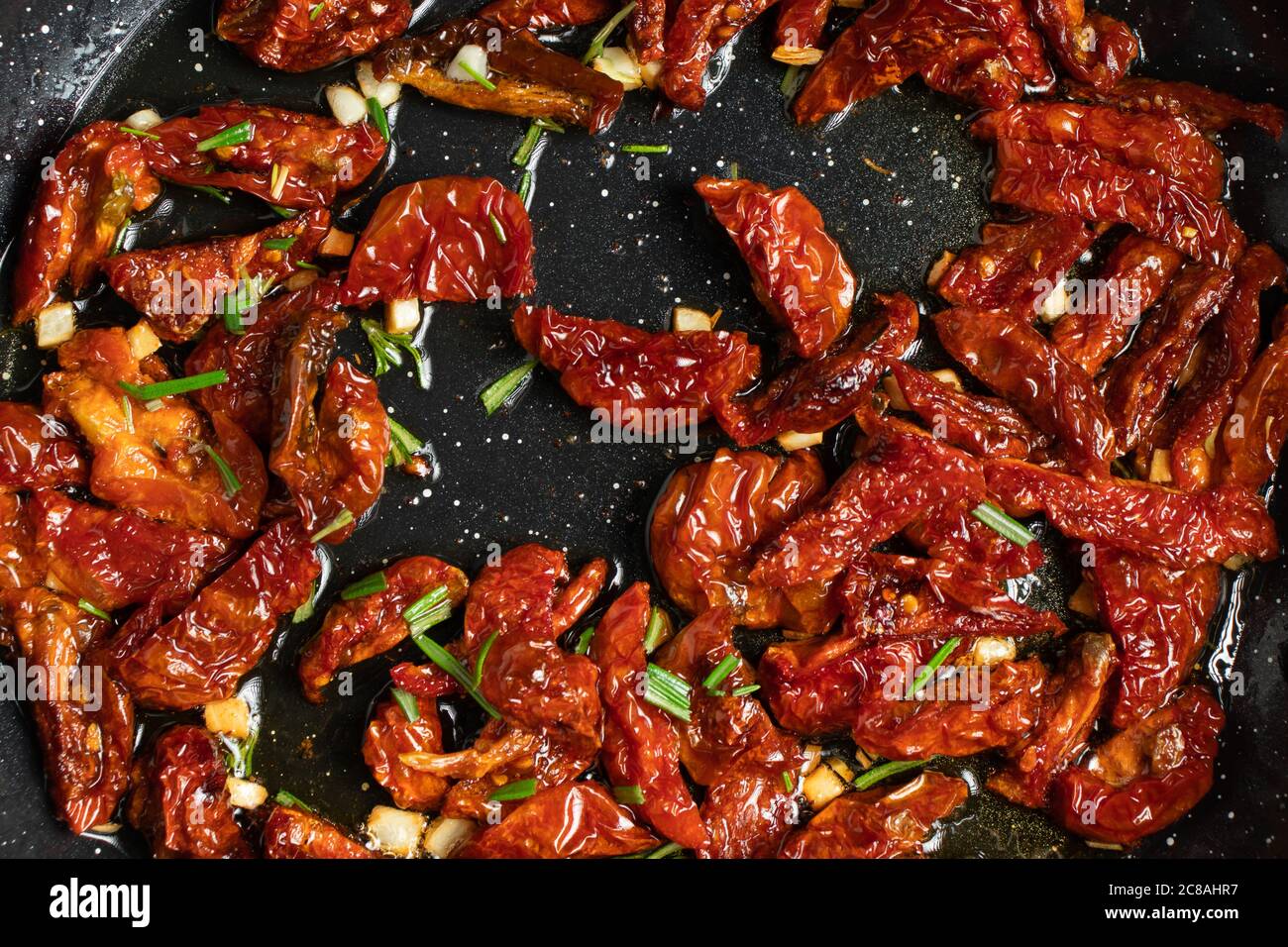 Panfried dried tomatoes with garlic and rosemary to make pasta sauce