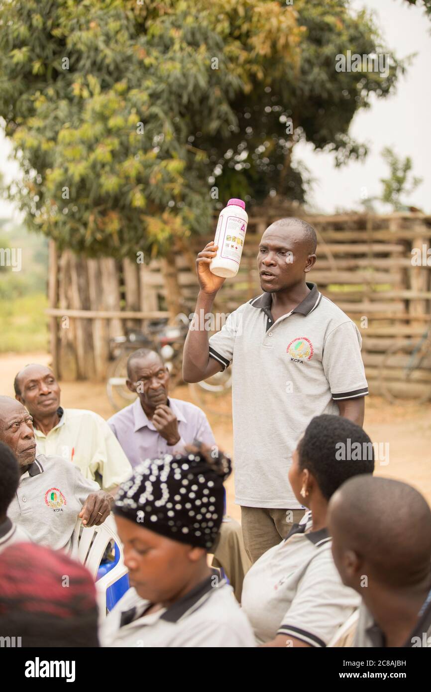 An agricultural extension worker educates small farmers and sells them farming inputs at a village community meeting in Kyotera District, Uganda. Stock Photo