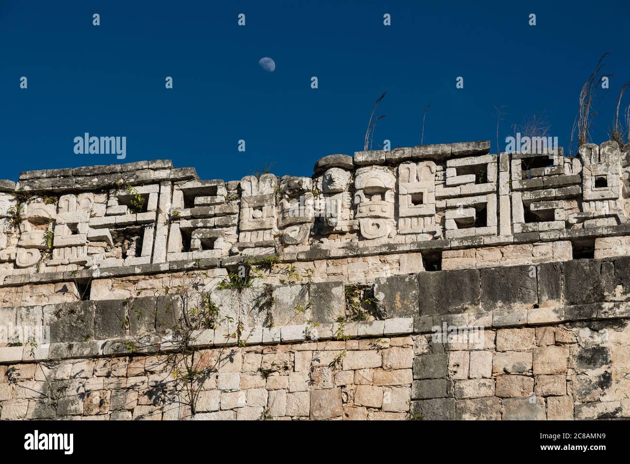 The moon rises over the roof comb of the Casa Colorado or Red House in the ruins of the great Mayan city of Chichen Itza, Yucatan, Mexico.  The Pre-Hi Stock Photo