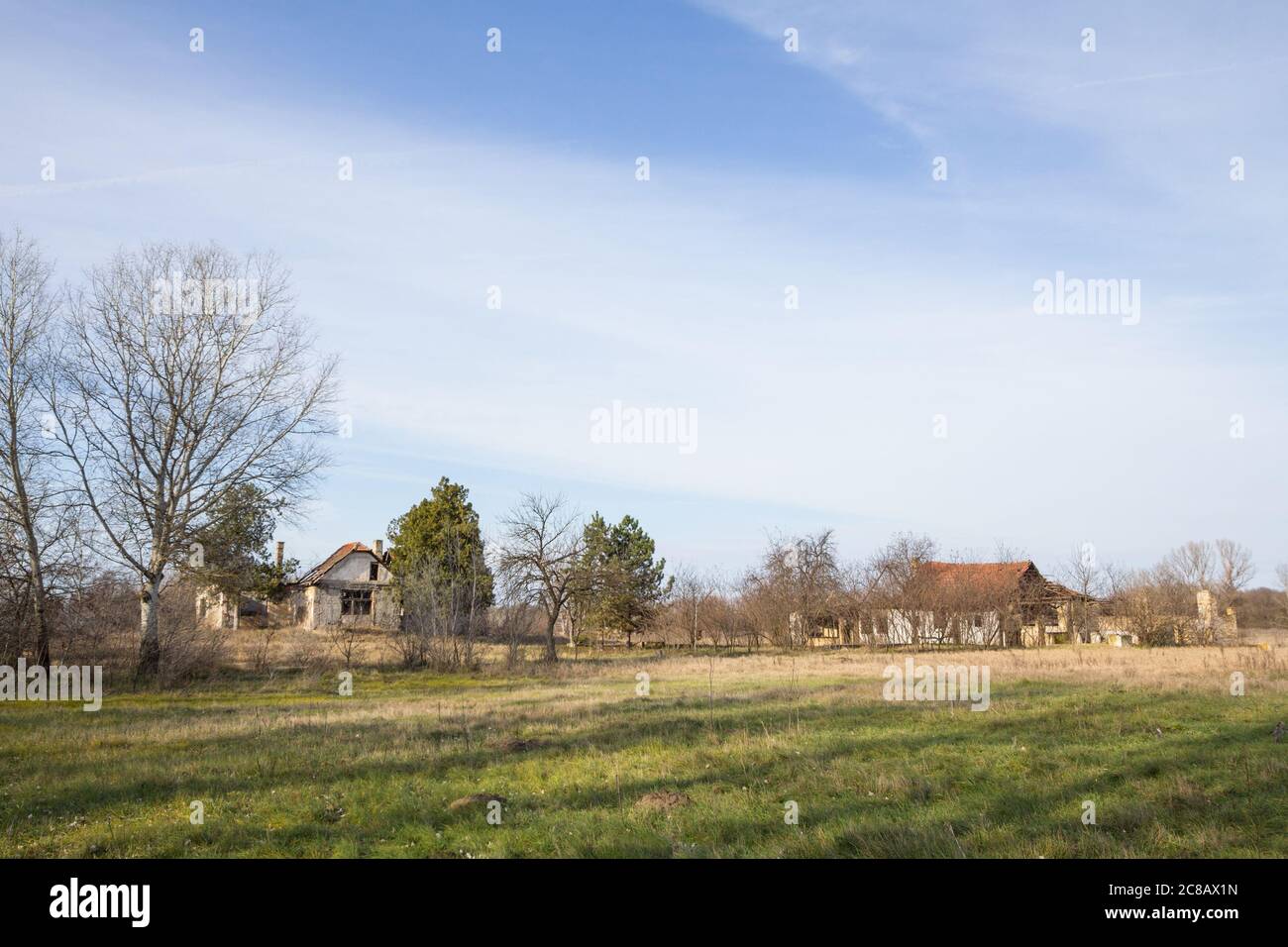 Panorama of an abandoned farm of Voivodina, in Serbia. The region of Balkans is hit by a severe rural exodus and emigration deserting the area.  Pictu Stock Photo