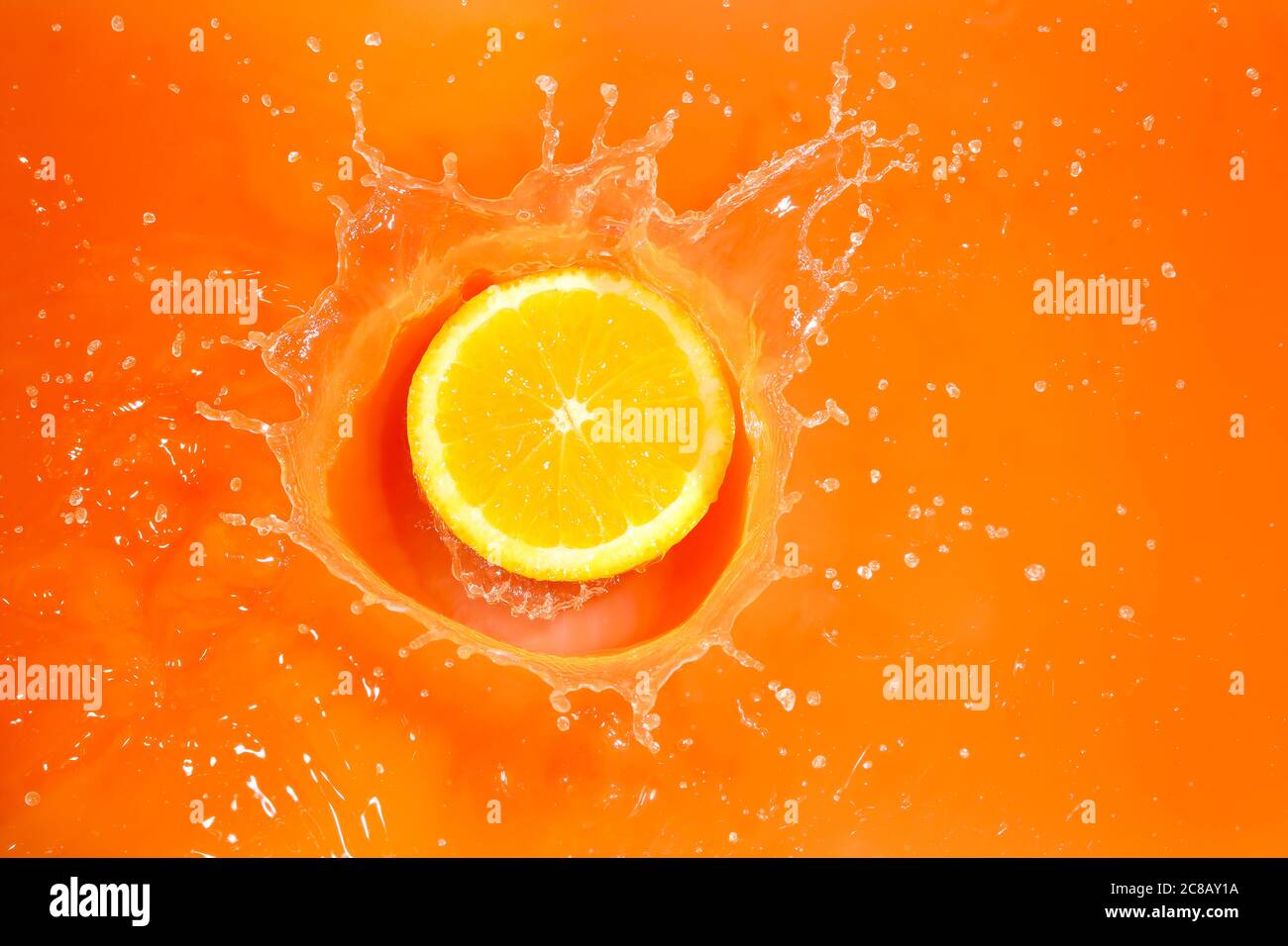 orange slice splashing into orange juice, high speed photography Stock Photo