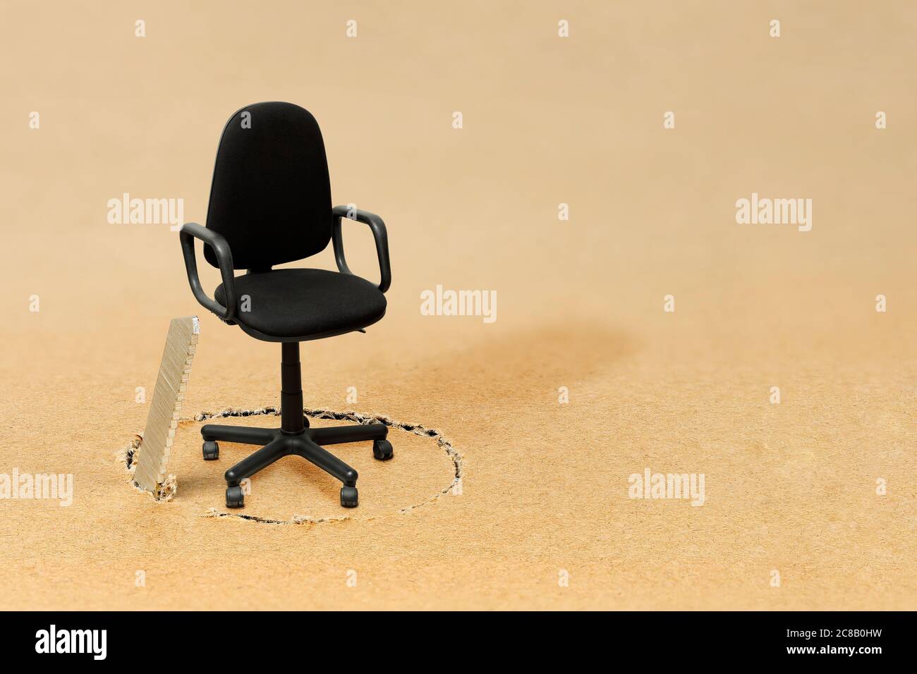 sawing the floor under an empty office chair, concept for undermining somebody's position Stock Photo