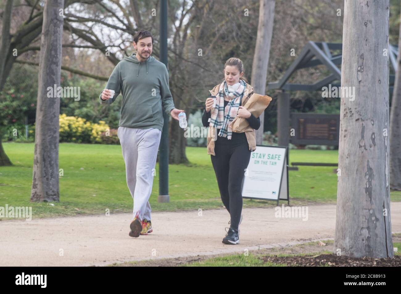 Melbourne, Australia 23 July 2020, a man and woman disregards the requirement to wear a face mask under health directions that came into force today, while walking on the Tan walking track around Melbourne’s Botanical Gardens. Credit: Michael Currie/Alamy Live News Stock Photo