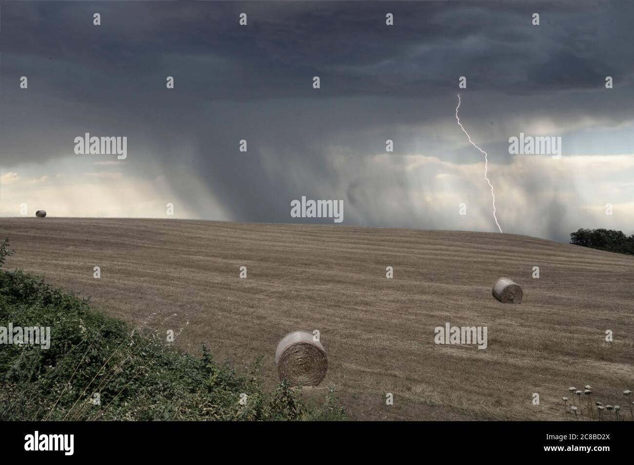 Dark clouds with lightning over field before a thunderstorm. Stock Photo