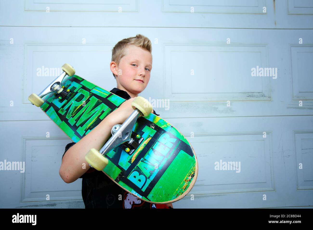 Feeling the wind in his hair - the young blond boy embraces his freedom of expression through his skateboarding. Stock Photo