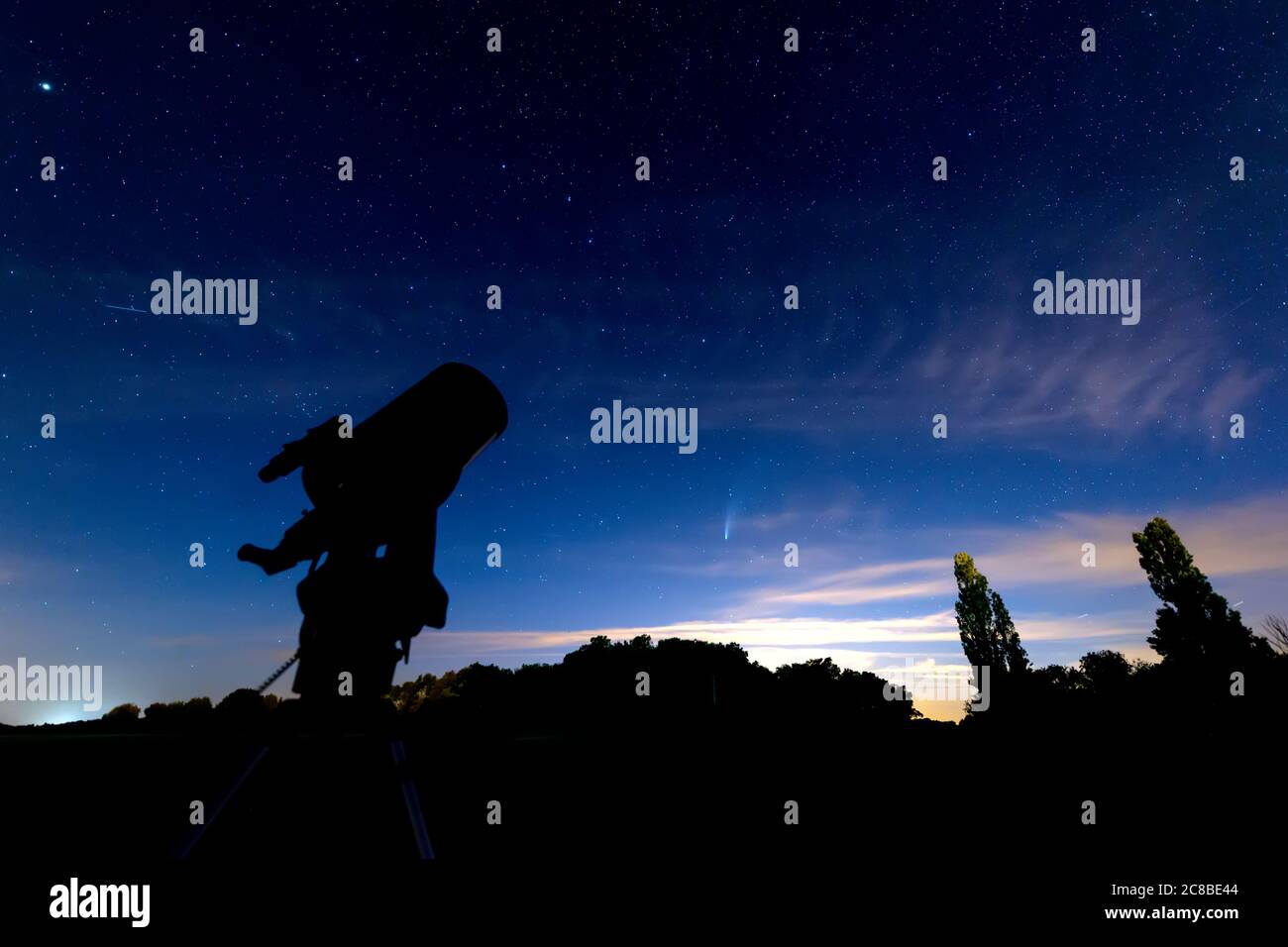 telescope silhouette under a dark blue starry sky at dusk, neowise comet visible under the Great Bear(Ursa Major)constellation. Stock Photo