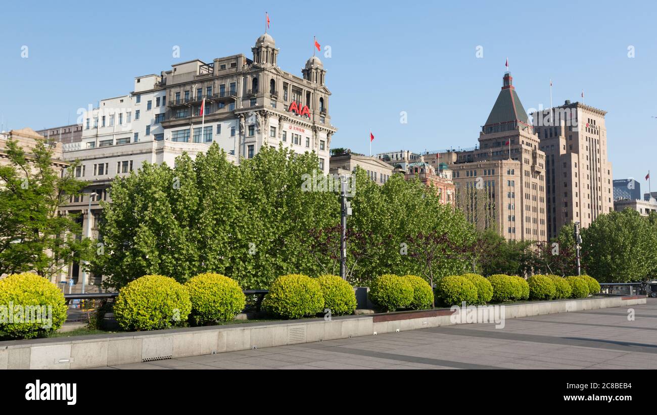 Shanghai, China - April 17, 2018: View on AIA building and Sassoon House (Fairmont Peace Hotel). Empty promenade of The Bund in the foreground. Stock Photo