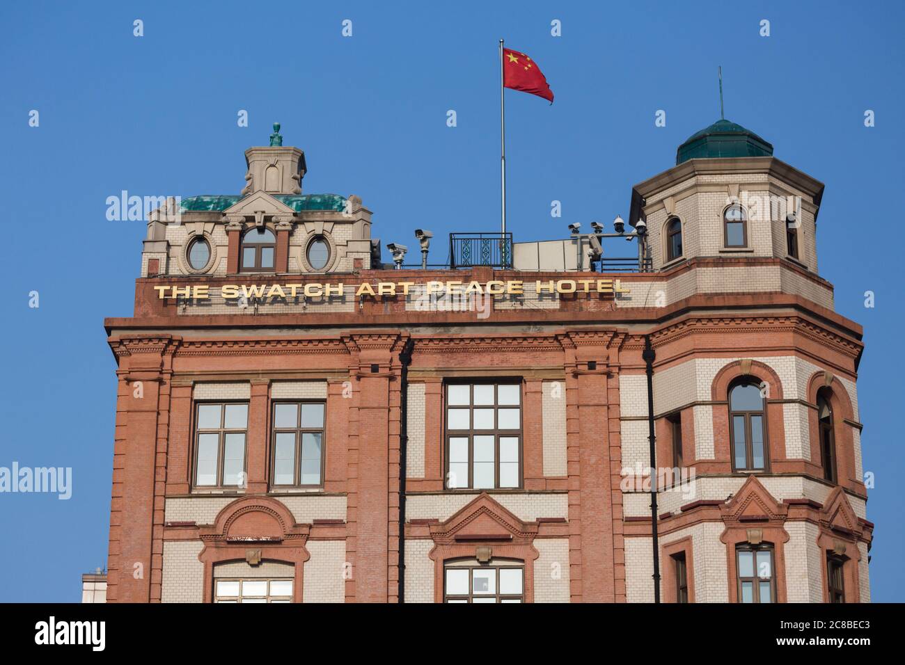 Shanghai, China - April 18, 2018: Close up of The Swatch Art Peace Hotel - one of the most famous hotels in Shanghai. With chinese flag and surveillan Stock Photo
