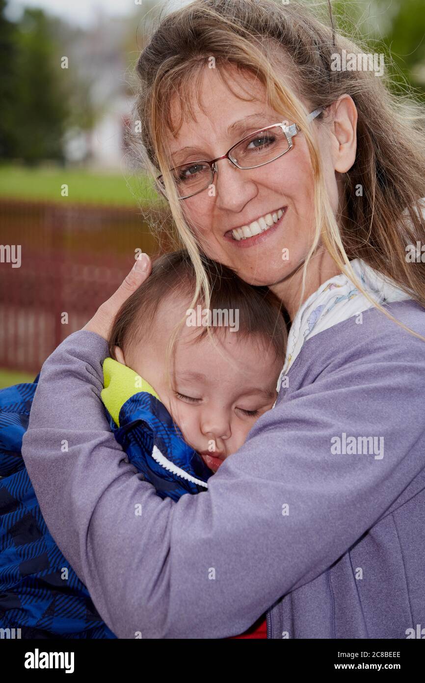 Woman holding infant while a relaxing day at Heritage Park Stock Photo