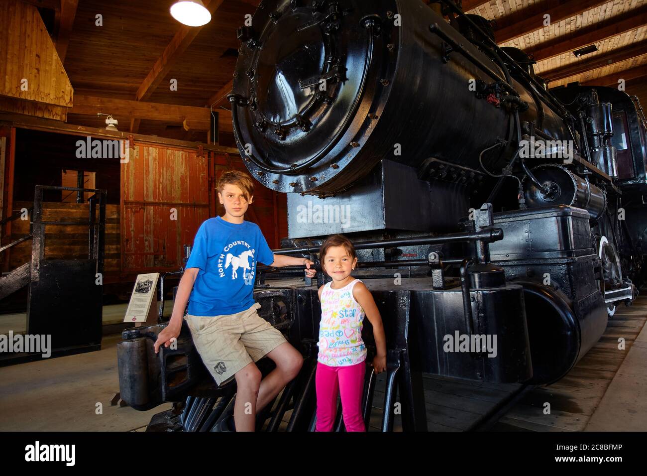 Two children posing in front of an old steam train engine at Heritage ...