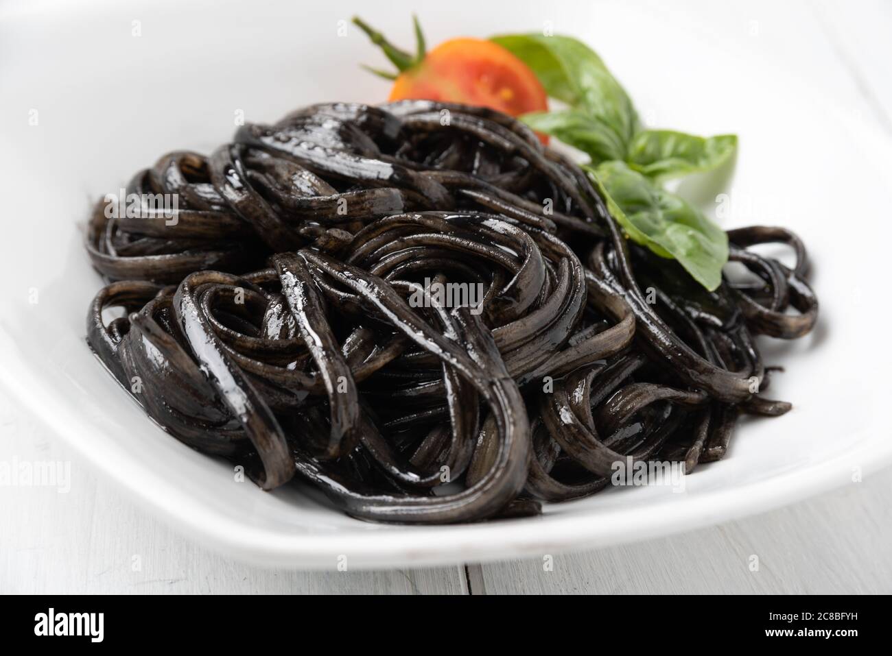 Plate of delicious linguine with squid ink sauce, a typical recipe of italian  pasta Stock Photo