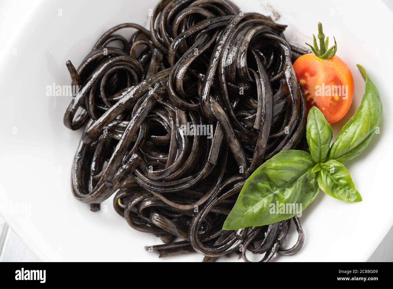 Plate of delicious linguine with squid ink sauce, a typical recipe of italian  pasta Stock Photo