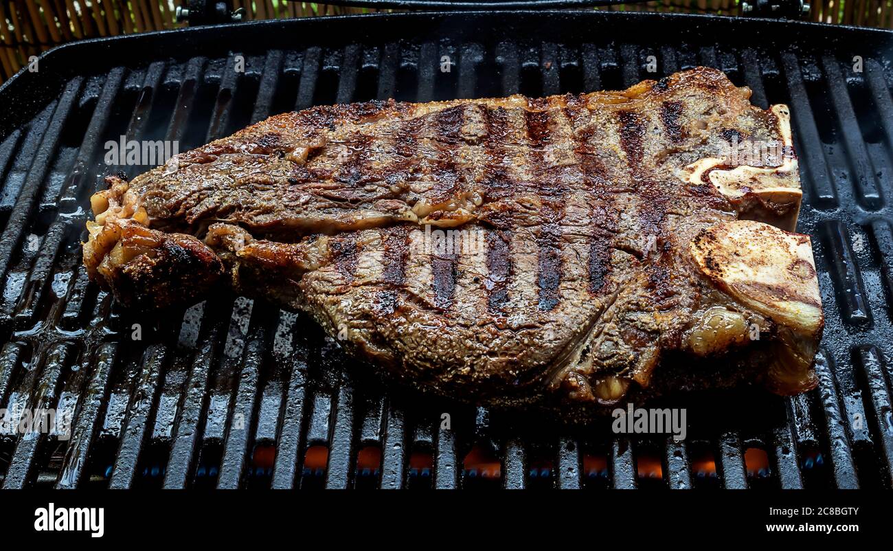 Cooking medium tbone steak on barbecue grill Stock Photo Alamy