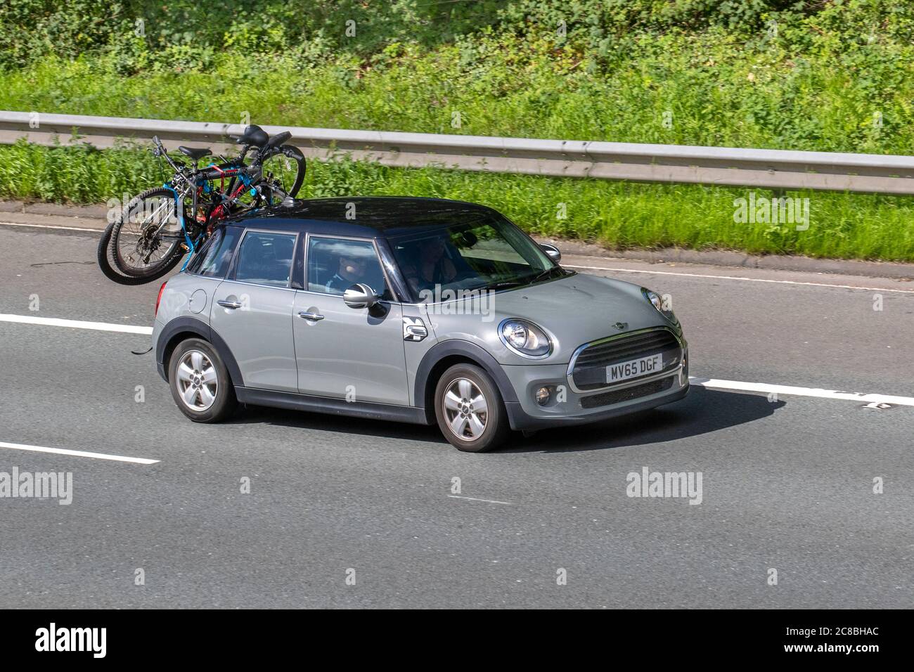 2015 grey Mini Cooper Auto bike bicycles cycles on car roof rack; Vehicular  traffic moving vehicles, cars driving vehicle on UK roads, motors, motoring  on the M6 motorway highway network Stock Photo -