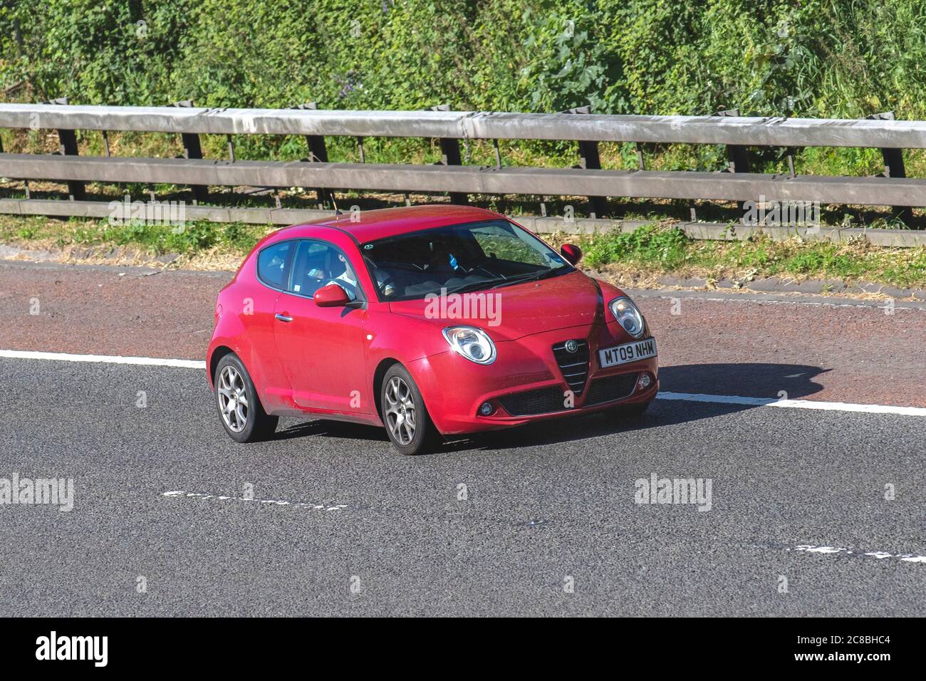 2009 red Alfa Romeo Mito Lusso T; Vehicular traffic moving vehicles, cars driving vehicle on UK roads, motors, motoring on the M6 motorway highway network. Stock Photo