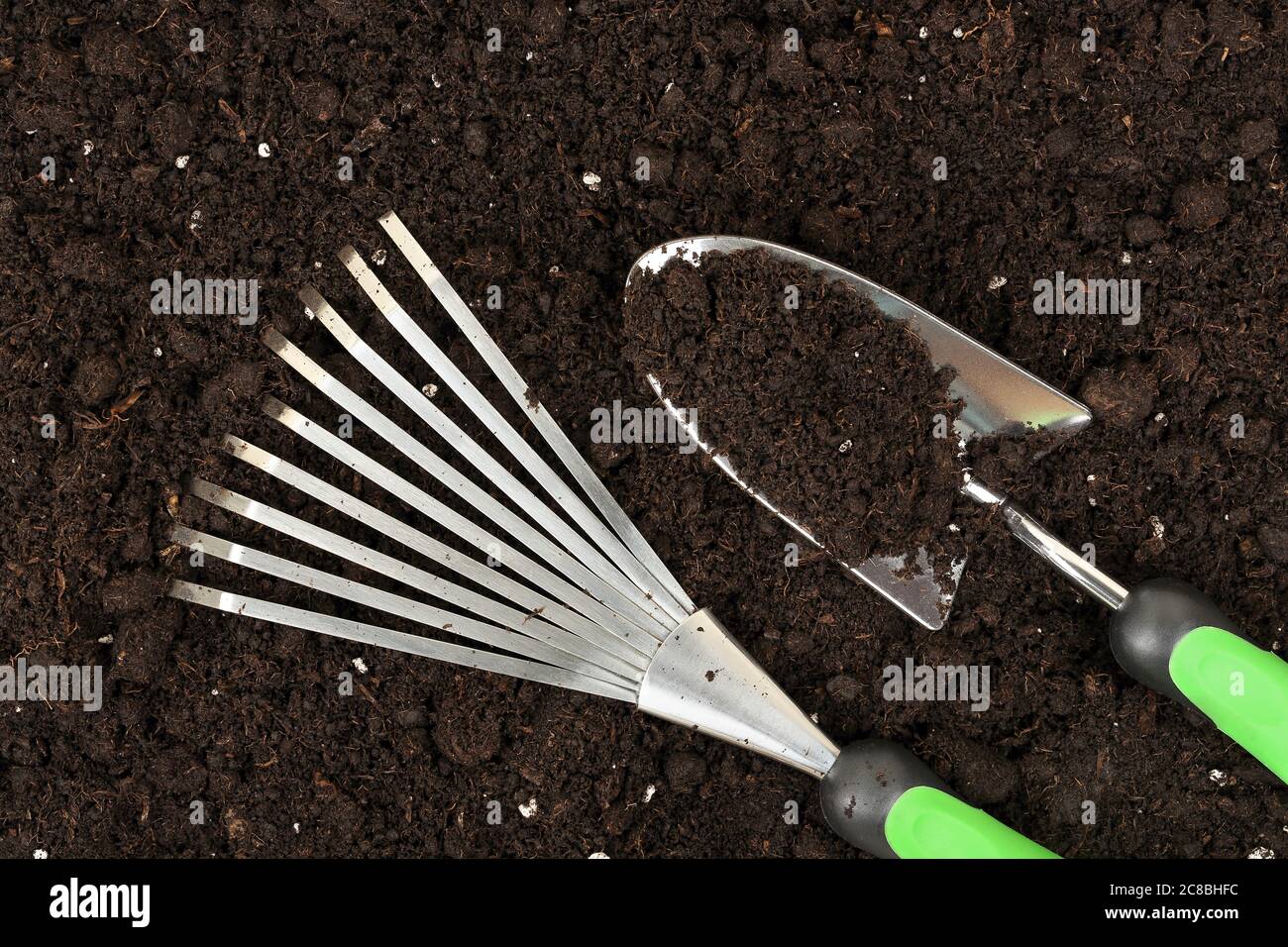 rake and spade on soil, gardening concept Stock Photo - Alamy