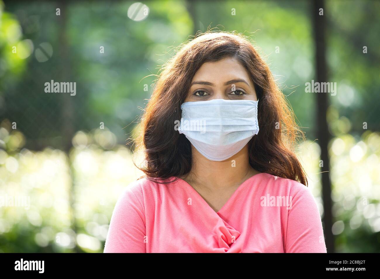 Woman with protective face mask at park Stock Photo
