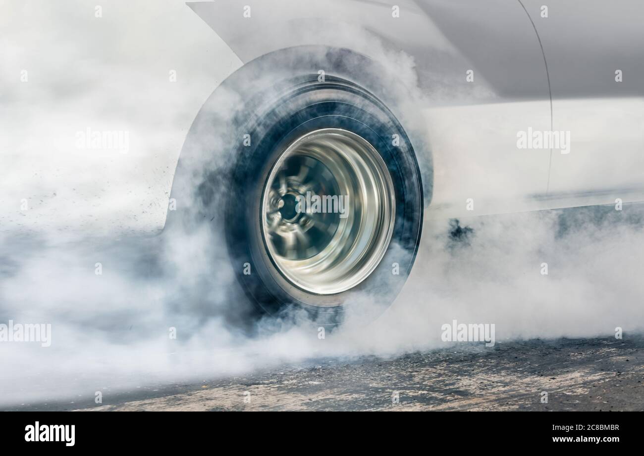 Drag racing car burns rubber off its tires in preparation for the race ...