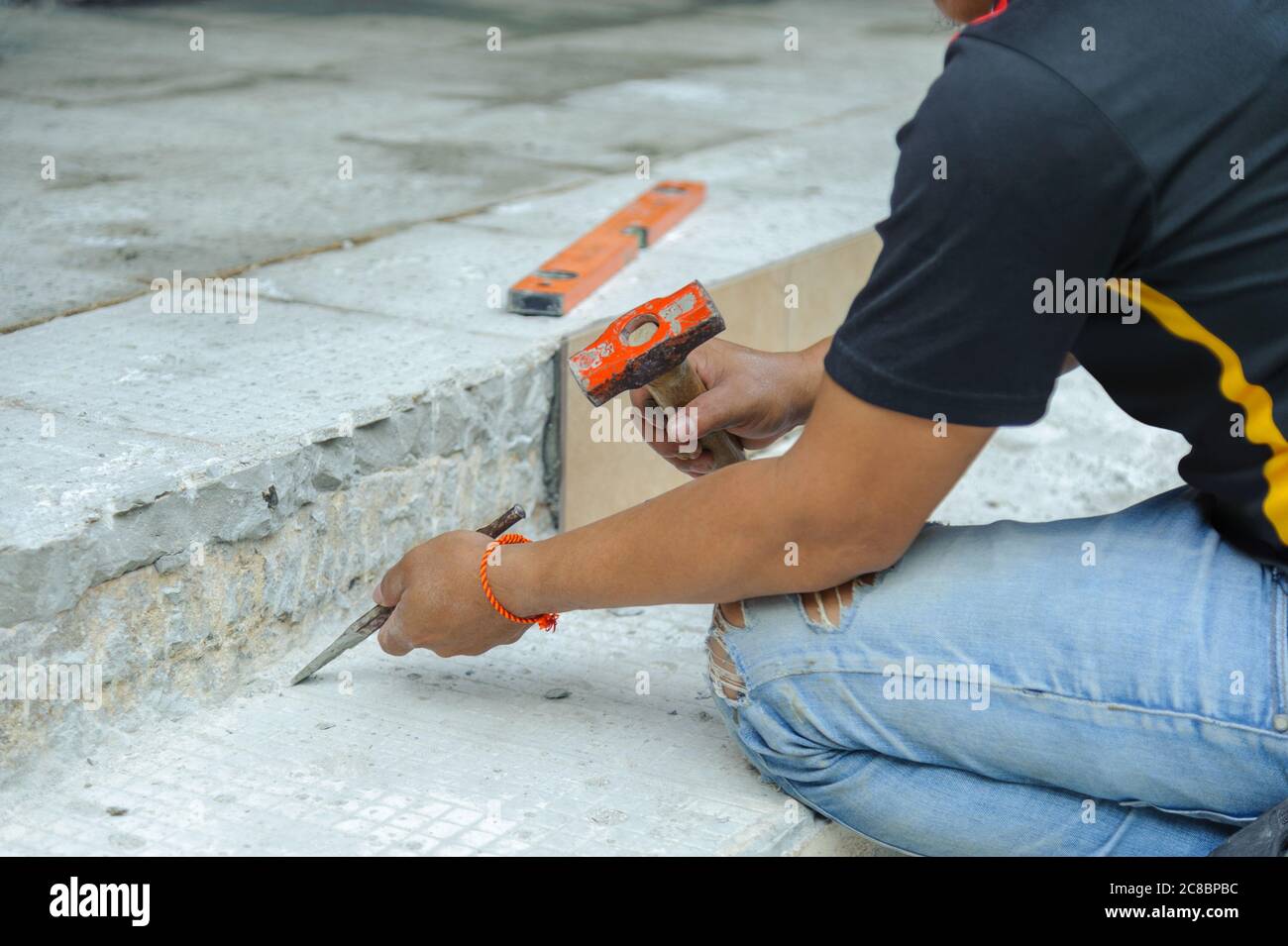 Man using hammer and chisel to dig up concrete floor during house renovations Stock Photo Alamy