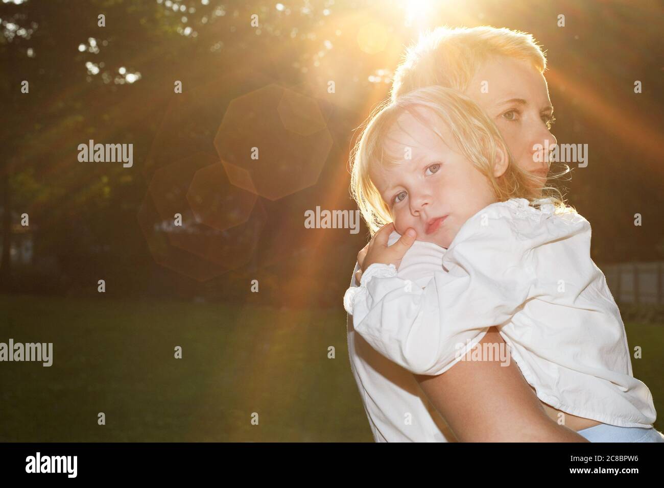 Mother hugging child in summer scene Stock Photo