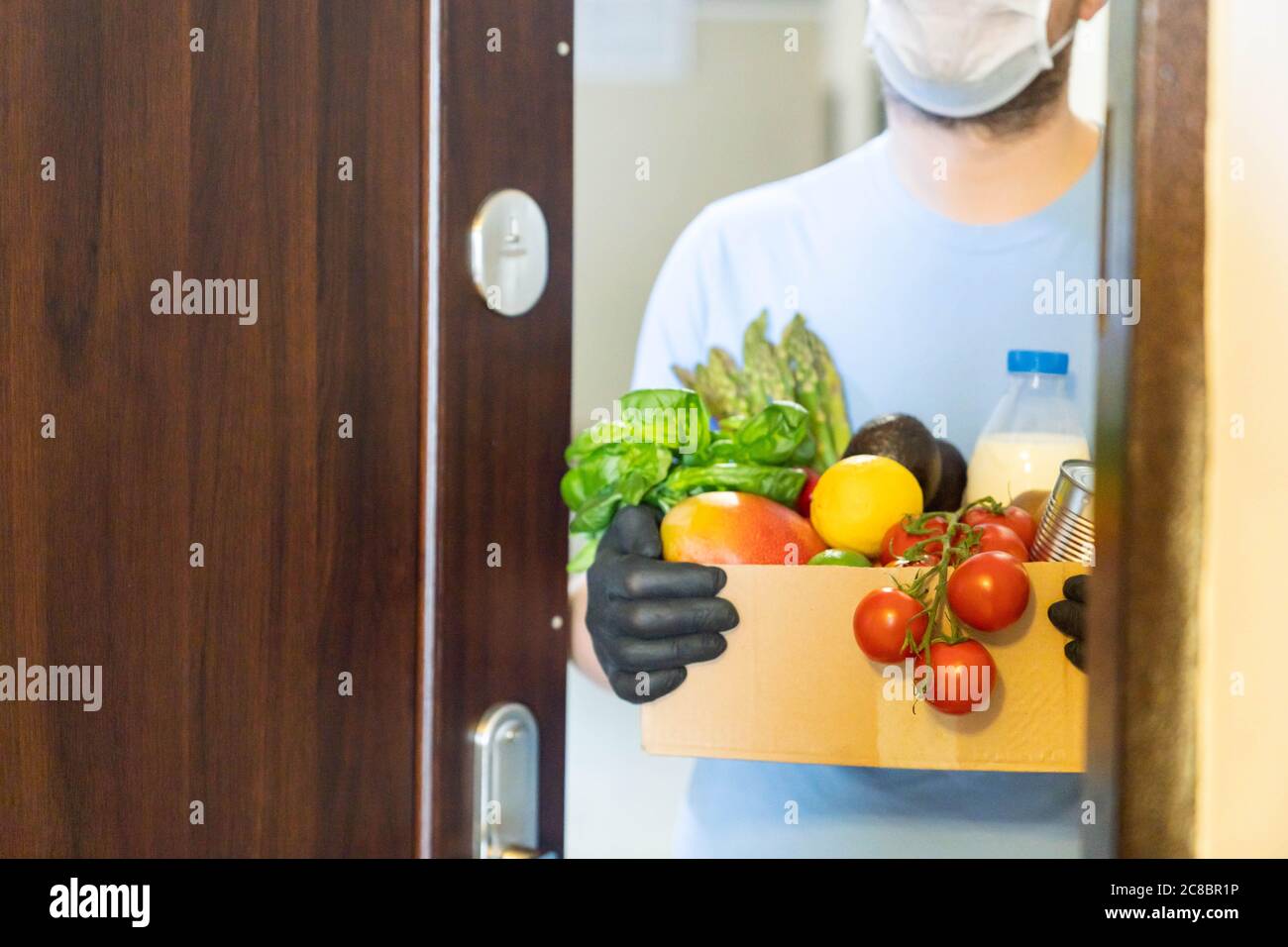 Safe food delivery concept delivery man holds gloceries Stock Photo