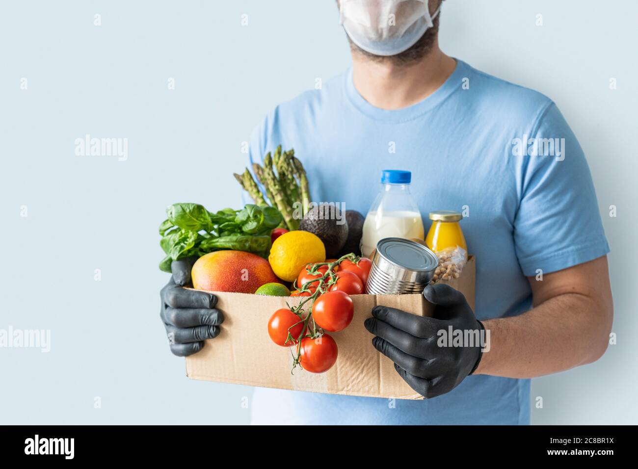 Safe food delivery concept delivery man holds gloceries Stock Photo