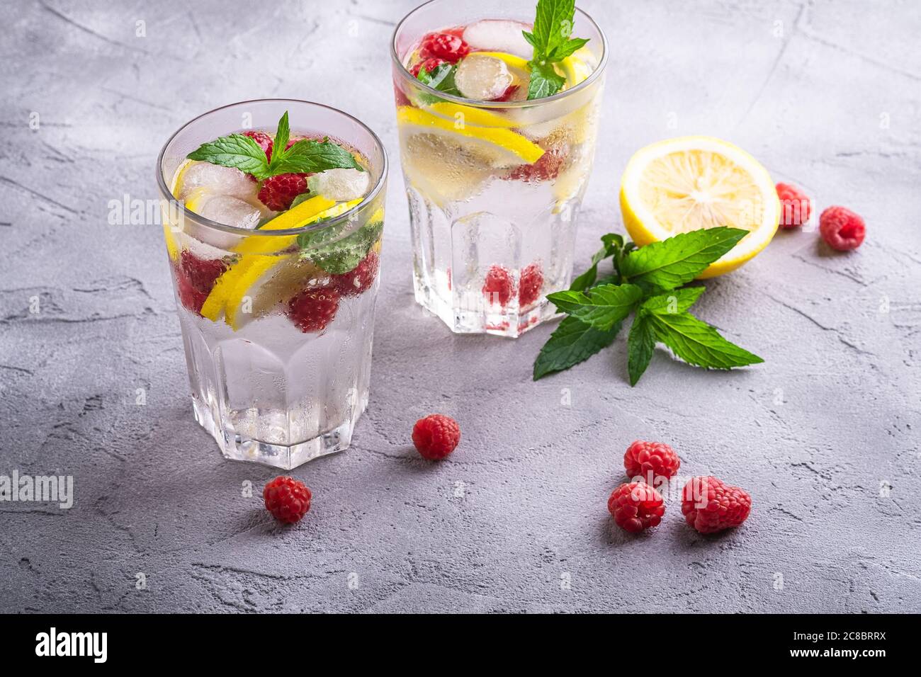 Fresh cold ice water drink with lemon, raspberry fruits and mint leaf ...