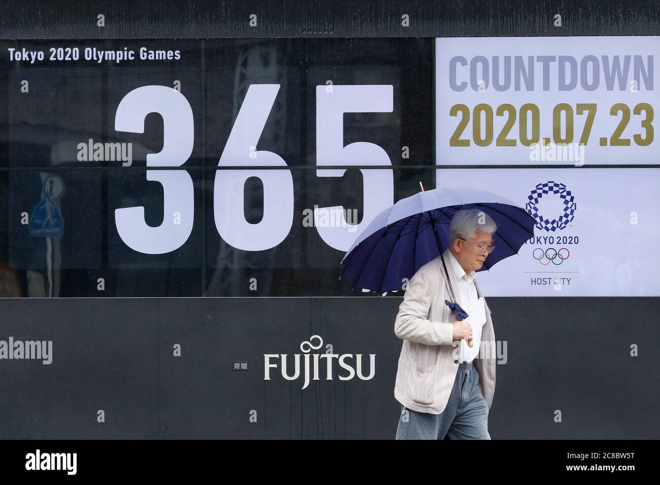 Tokyo Japan 23rd July A Man Holding An Umbrella Walks Past A Countdown Calendar Showing 356 Day To Start Tokyo Olympic Games The Calendar Marks The Day To Go Opening Tokyo Japan 23rd July A Man Holding An Umbrella Walks Past A Countdown Calendar Showing 356 Day To Start Tokyo Olympic Games The Calendar Marks The Day To Go Opening