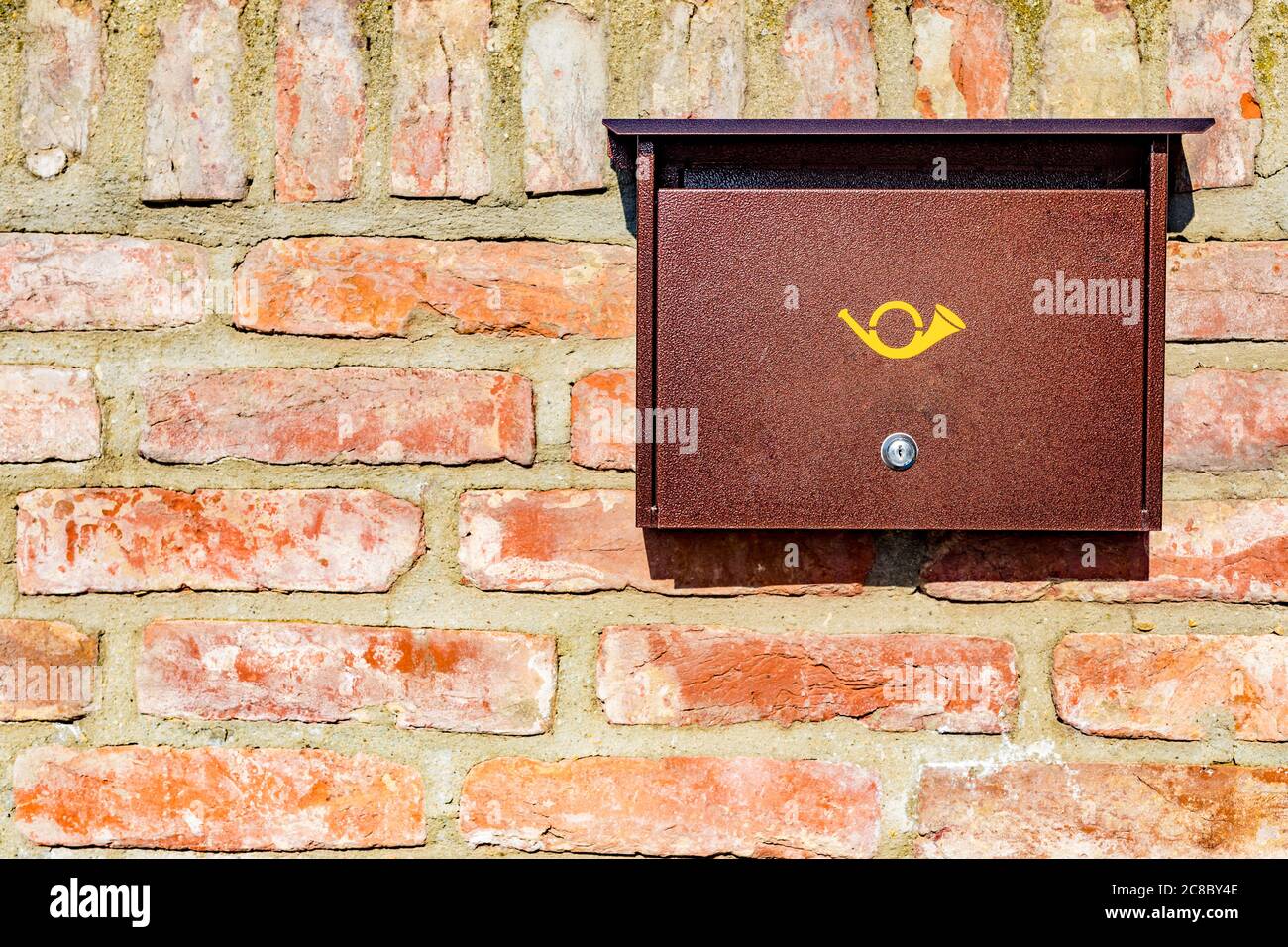 Brown mailbox on brick wall, vintage mailbox style. Stock Photo