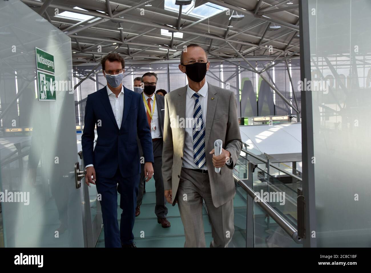 22 July 2020, North Rhine-Westphalia, Cologne: Hendrik Wüst (l-r), Minister of Transport of the State of North Rhine-Westphalia, and Johan Vanneste, Managing Director of Flughafen Köln/Bonn GmbH, come with mask to the presentation of the feasibility study on the subject of flight taxis at Cologne Bonn Airport - Perspective of a new technology. Photo: Horst Galuschka/dpa Stock Photo
