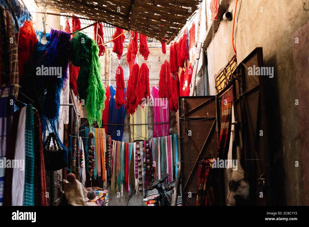 Market stand with colored silk threads and scarfs on the street in the Marrakesh souk in Morocco Stock Photo