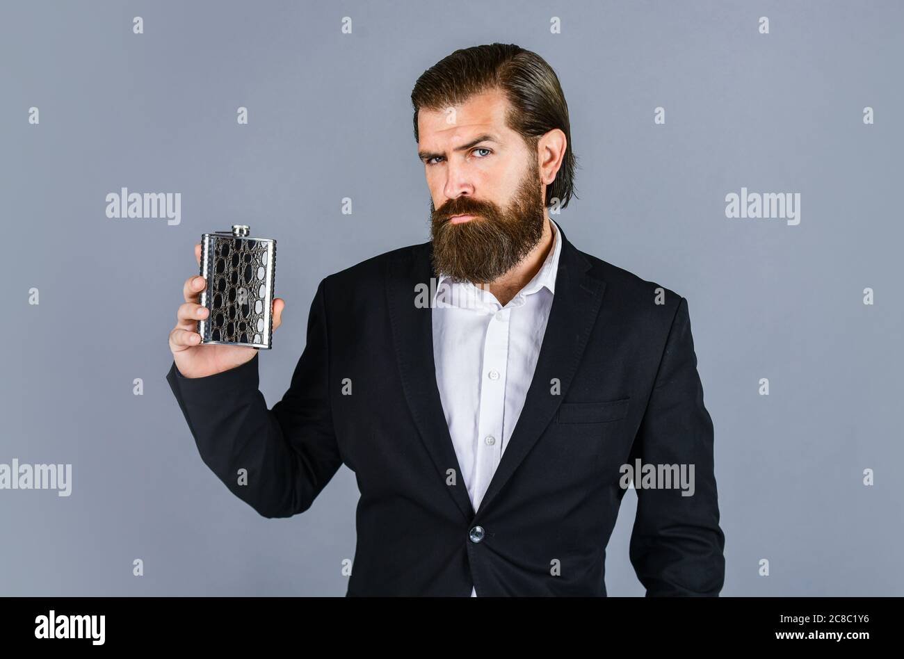 best taste. man drinks strong alcohol from iron flask while relaxing. Hip flask for whiskey. vintage gentleman gift shop. Brutal businessman drinking alcohol. Man with his booze flask. Stock Photo