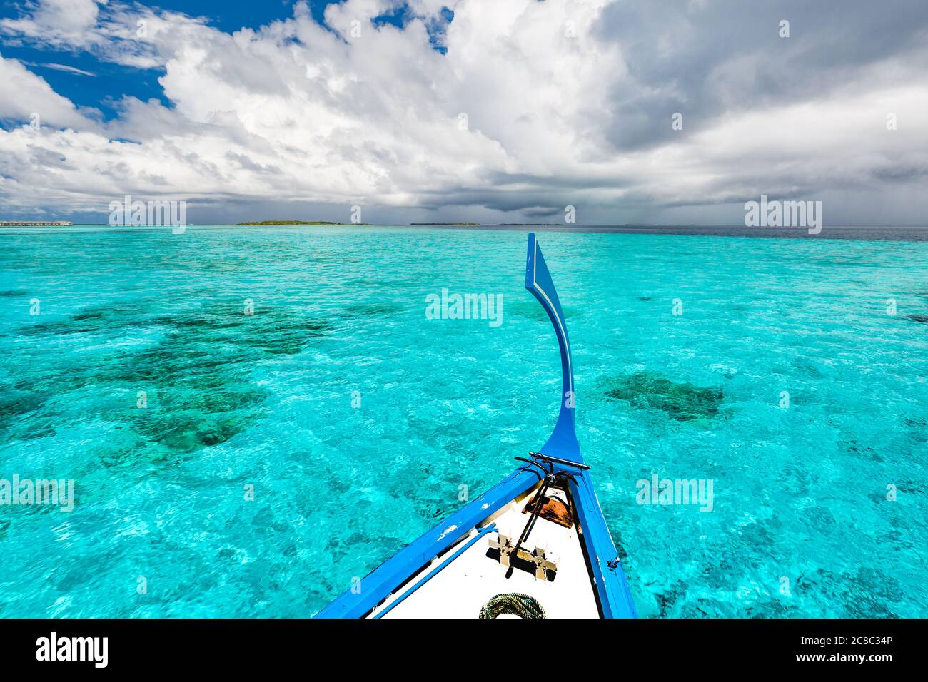 View from the deck of the traditional Maldivian wooden fishing boats on landscape of tropical island with a sandy beach and palm trees Stock Photo