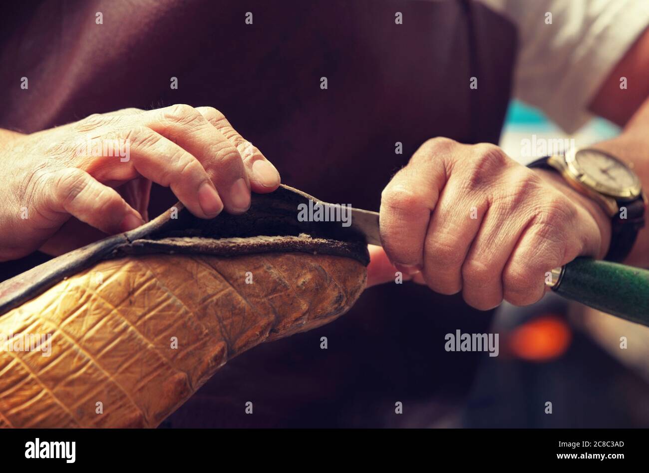 Cobbler craftsman fixing leather boot using tools Stock Photo