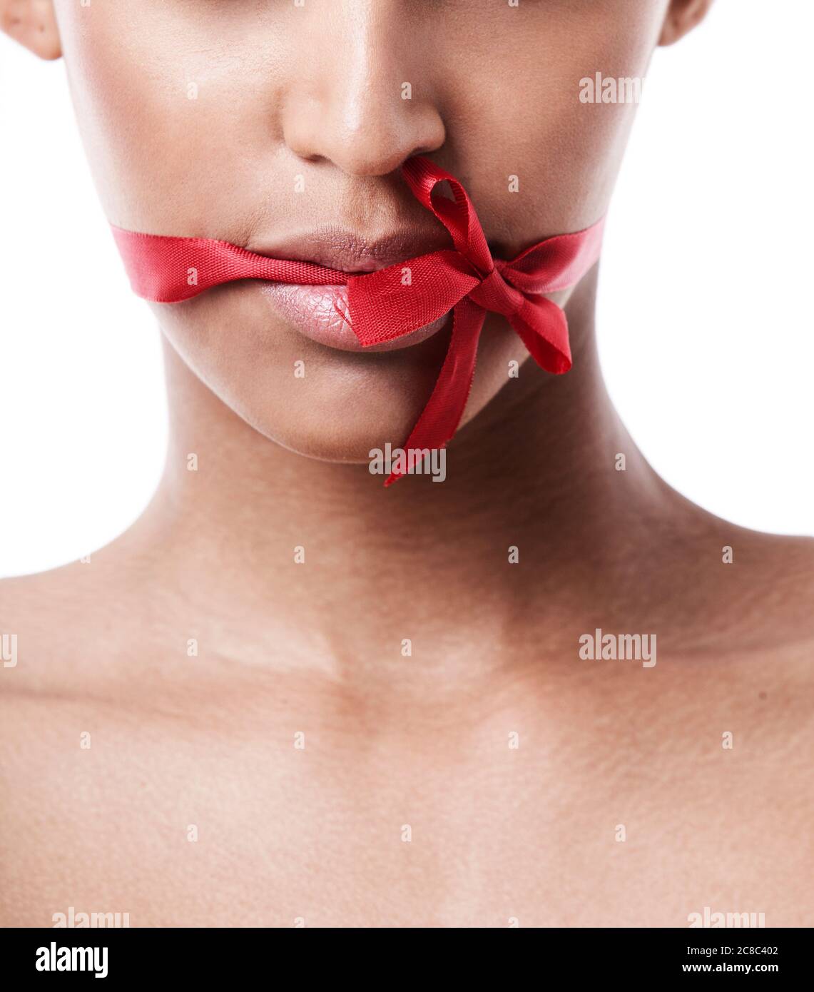 Red bow tied over womans mouth Stock Photo