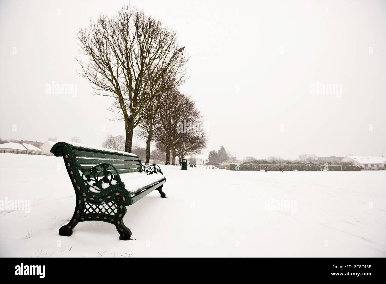 Park bench and park covered in snow Stock Photo - Alamy