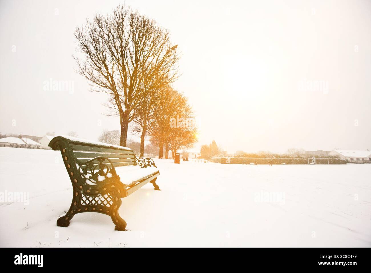Park bench and park covered in snow Stock Photo - Alamy