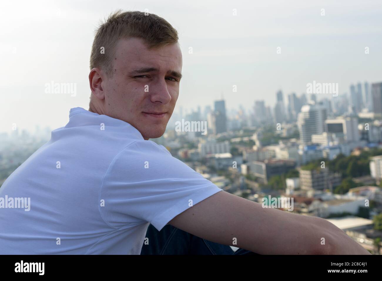 Portrait of young man with blond hair against view of the city Stock ...