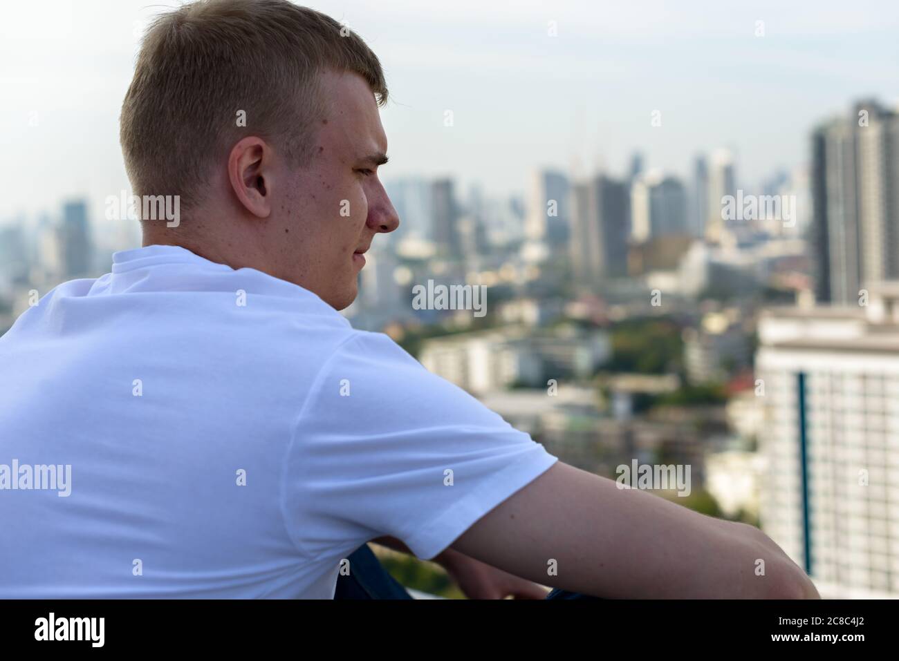 Portrait of young man with blond hair against view of the city Stock ...