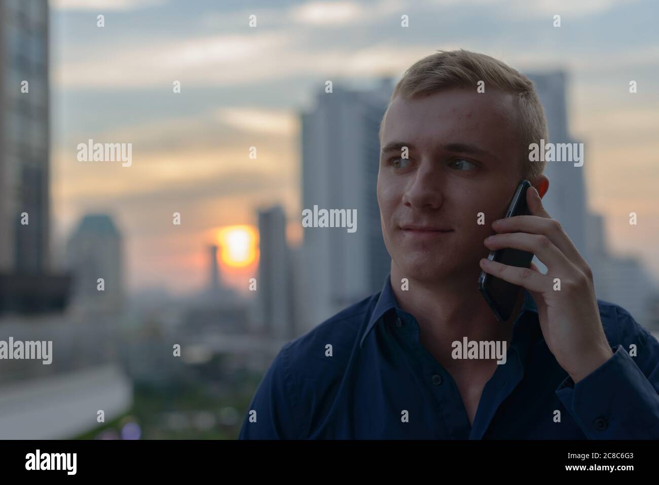 Portrait of young blond businessman against view of the city Stock ...