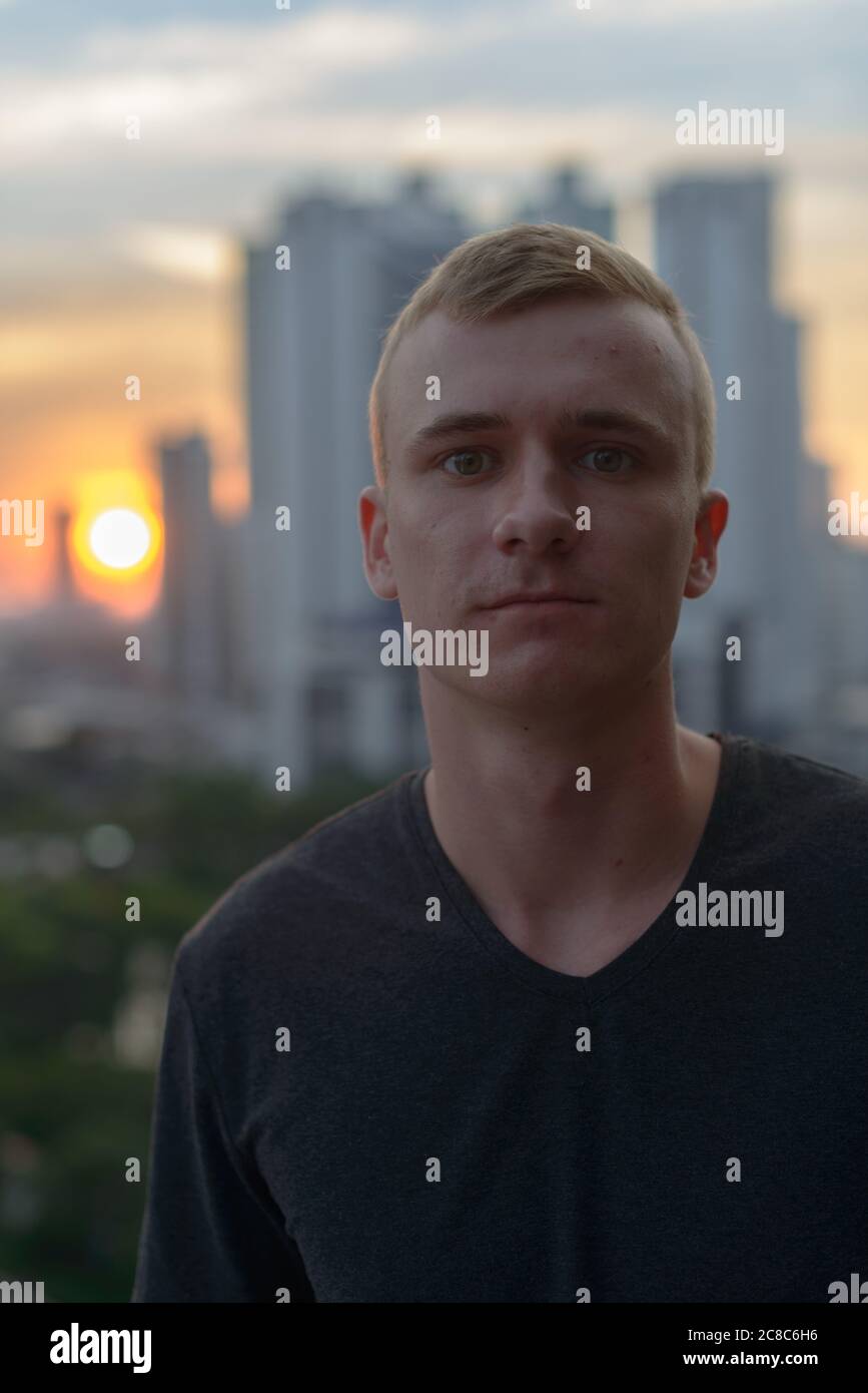 Portrait of young man with blond hair against view of the city Stock ...