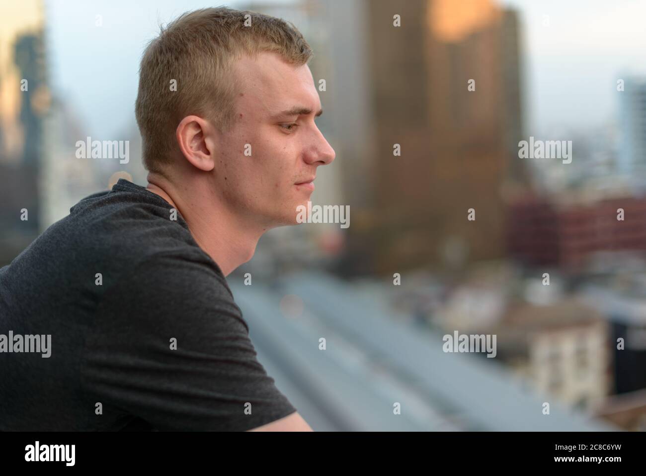Portrait of young man with blond hair against view of the city Stock ...