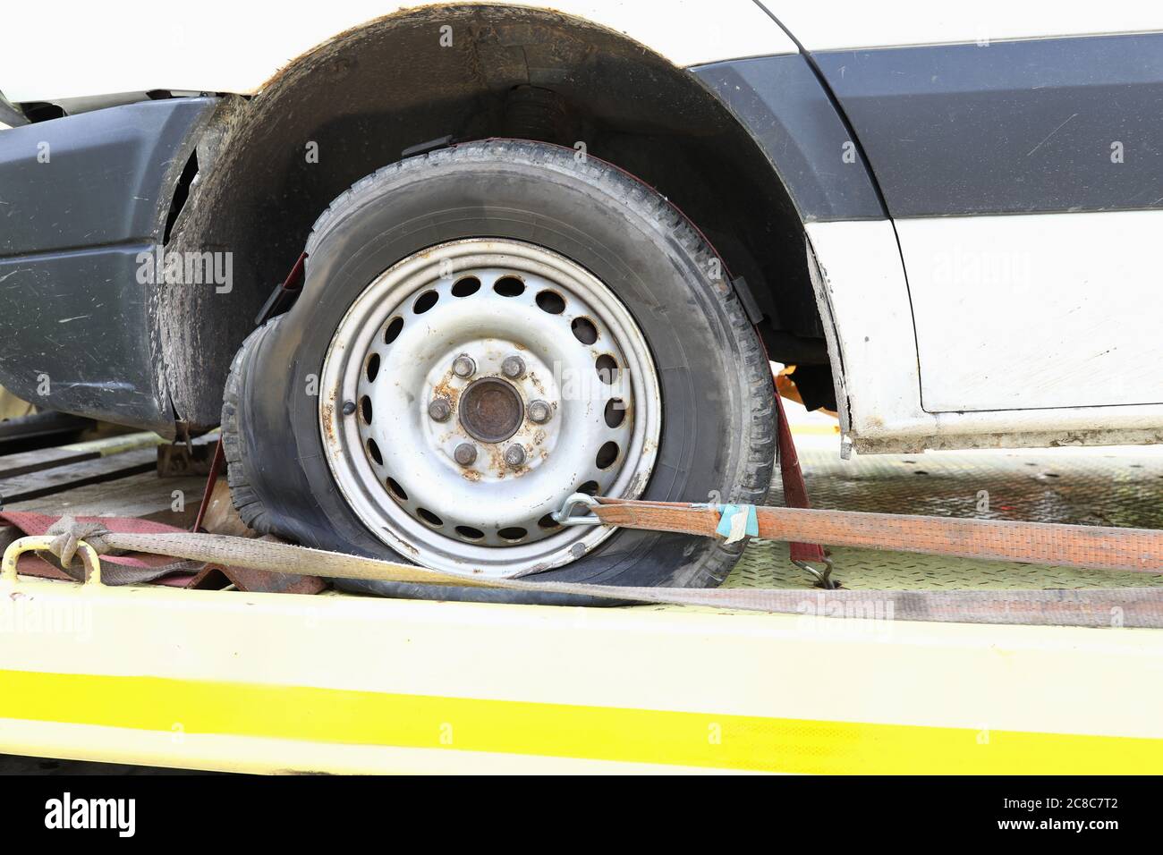 Car is on tow truck with flat tire closeup Stock Photo