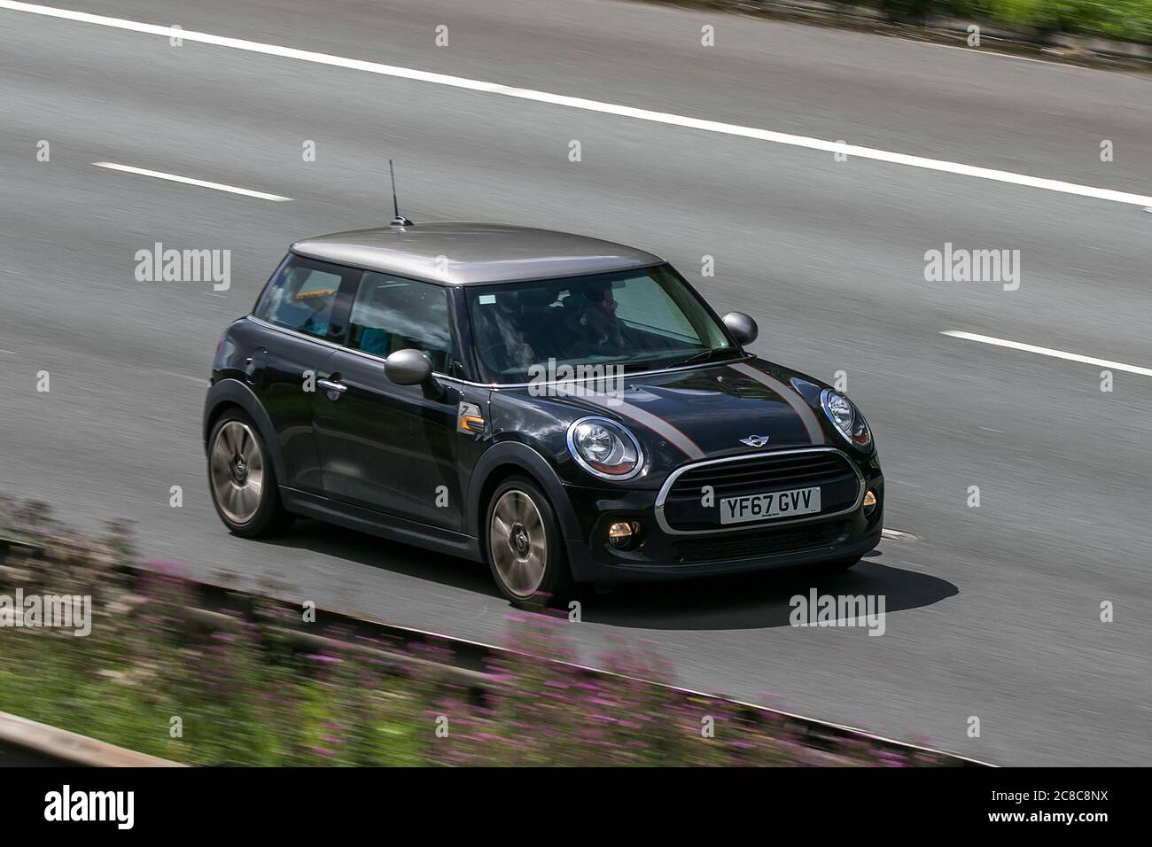 A 2017 Mini Cooper Seven Black Car Hatchback Petrol driving on the M6motorway near Preston in Lancashire, UK Stock Photo