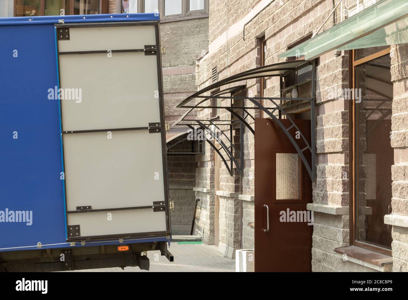 Unloading or loading goods to the store warehouse. Delivery of things. Truck near the door. Moving concept Stock Photo